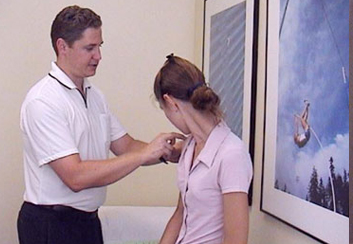Dr Justin Paoloni examines a patient's shoulder